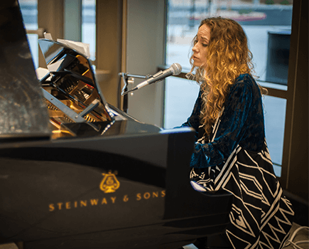 Woman singing and playing on grand piano