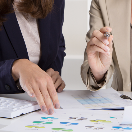 Two women looking over pie charts