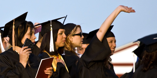 Close up of a group of women in their caps and gowns at their graduation ceremony.