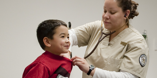 Female Nevada State nursing student hearing the heart beat of a child with her stethoscope.