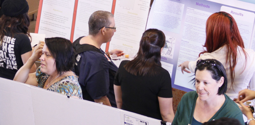 Group of people viewing projects that belong to Nevada State students.