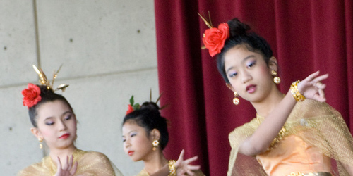 Three young girls dressed up in costume performing on stage