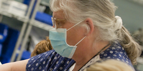 Woman with hospital mask on working on something