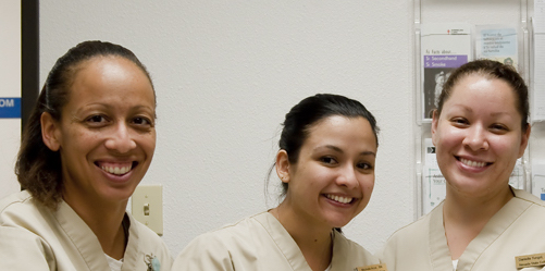 Three female nursing students smiling at camera