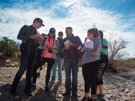 Group of students and professor outside among desert scenery