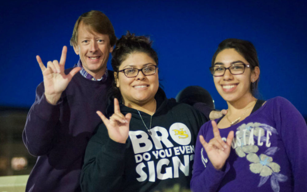 Picture of a NSC Professor and two students showing American Sign Language sign for 