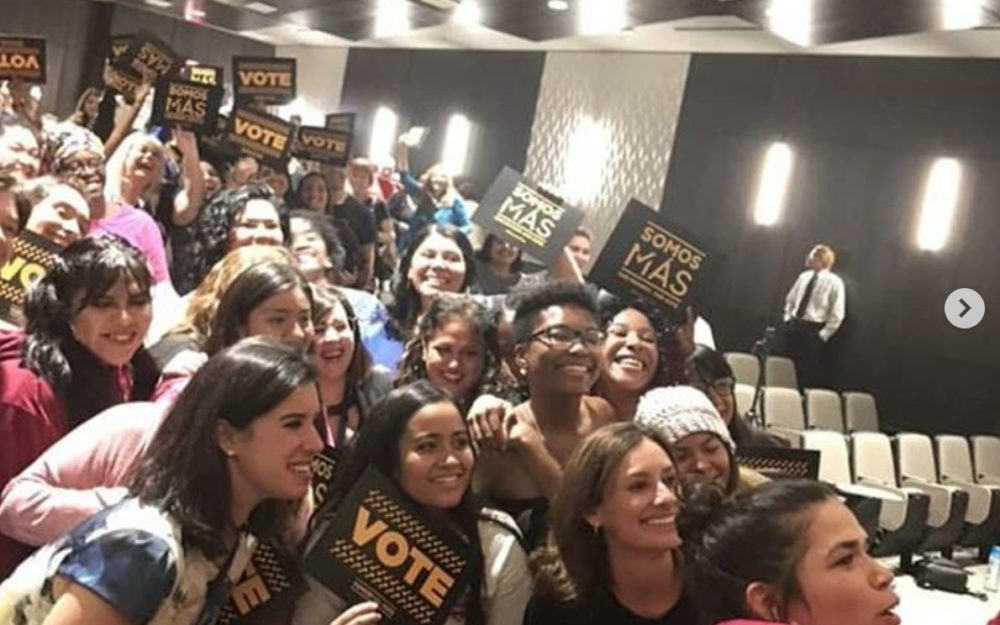 Large group picture of people holding up signs that say 