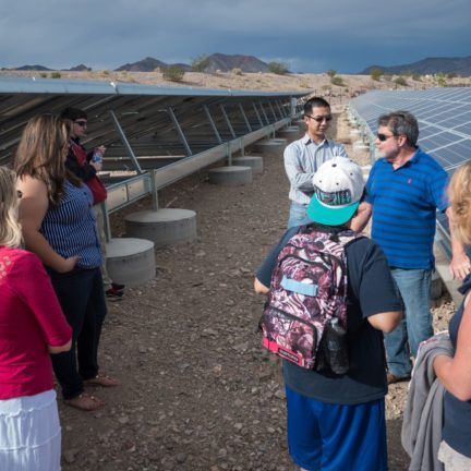 Group of people talking by solar panels at Liberal Arts & Sciences Building